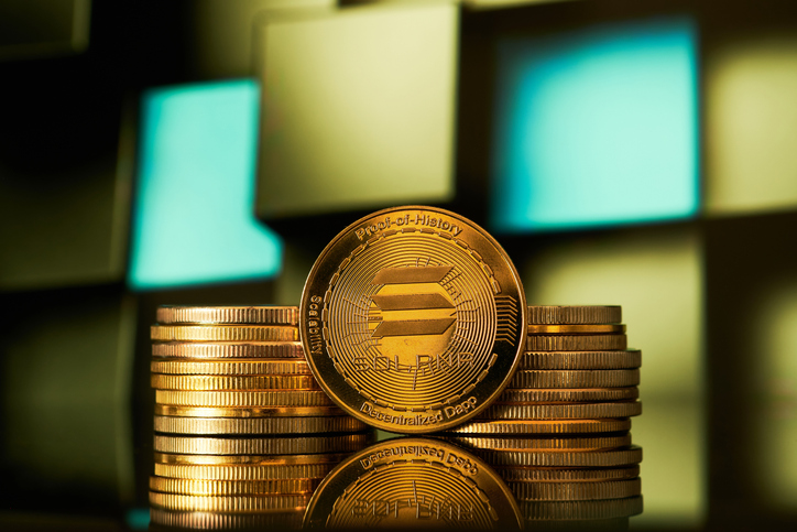 Golden Solana cryptocurrencies stacked on a geometric background that reflects light